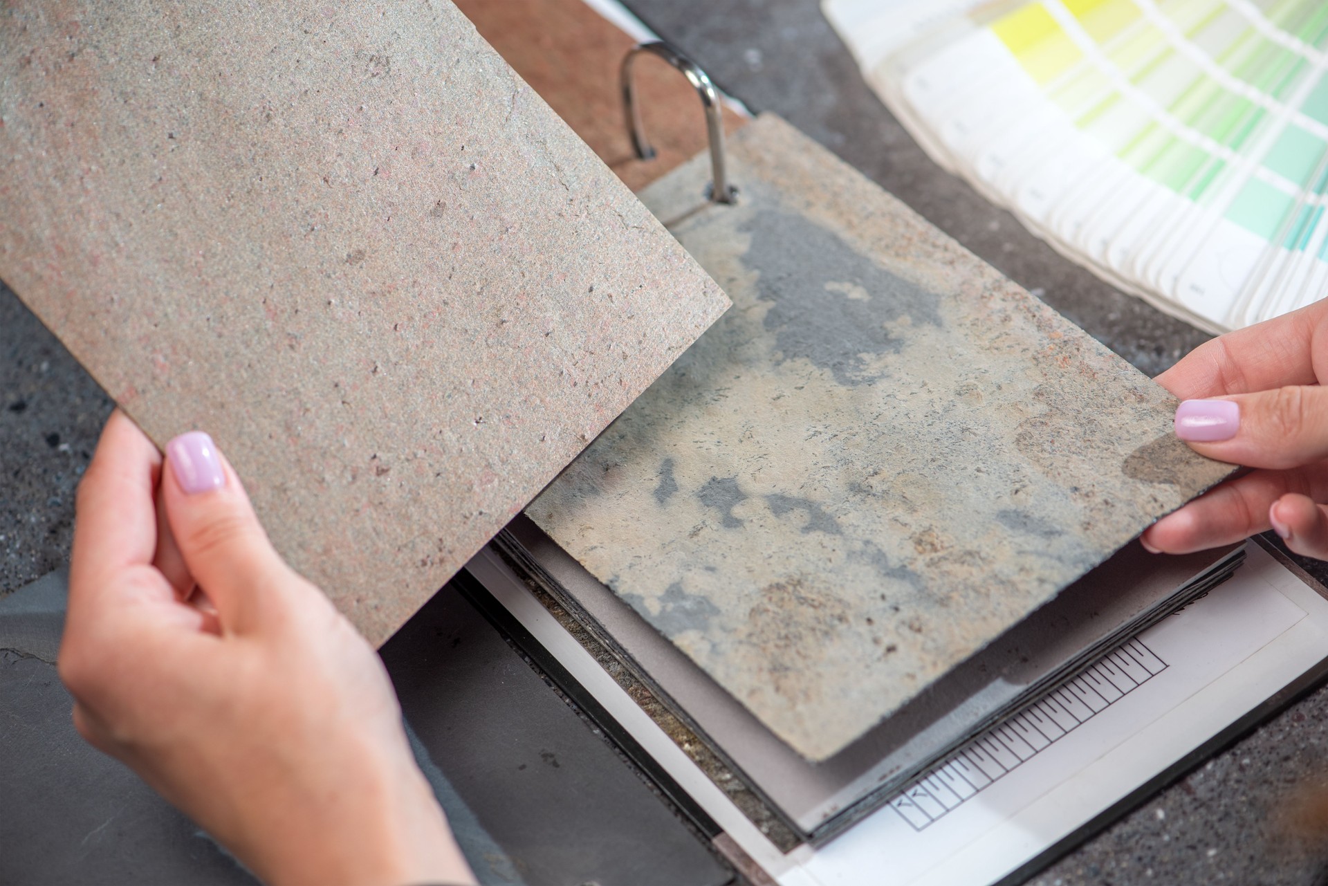 L’architecte choisit à la main un échantillon de matériau en pierre ou une collection de texture de carreaux sur la table en studio. Designer travaillant pour l’architecture d’intérieur et le projet de design de meubles.